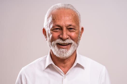 Portrait of cheerful senior man who is looking at camera and smiling.