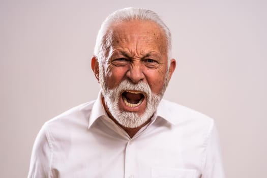 Portrait of furious senior man who is screaming.