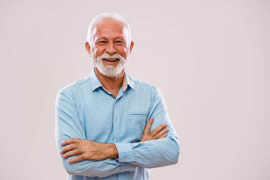 Studio shot portrait of cheerful senior man.