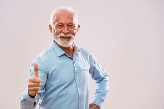 Portrait of cheerful senior man who is looking at camera and smiling.