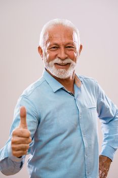 Portrait of cheerful senior man who is looking at camera and smiling.