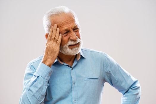 Portrait of senior man who is having headache.