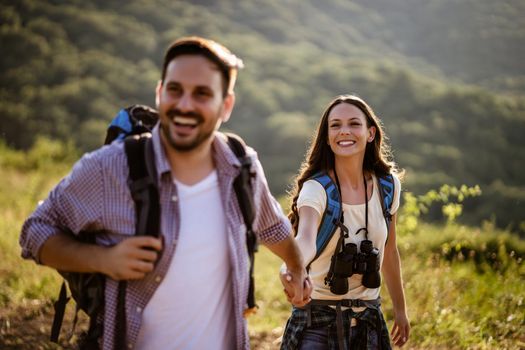 Happy couple is hiking in mountain in summertime.
