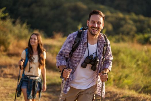 Happy couple is hiking in mountain.