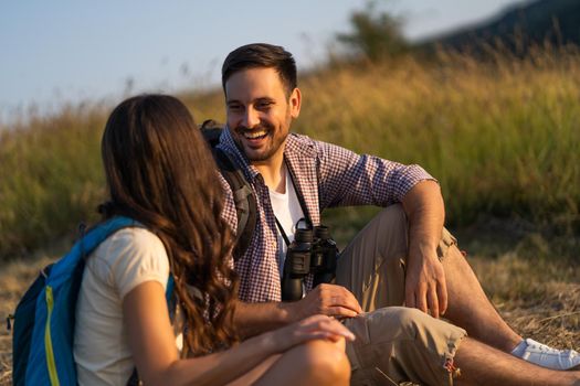 Happy couple is hiking in mountain. They are relaxing.