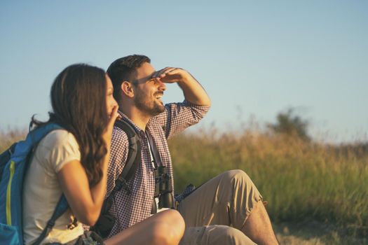 Happy couple is hiking in mountain. They are relaxing.