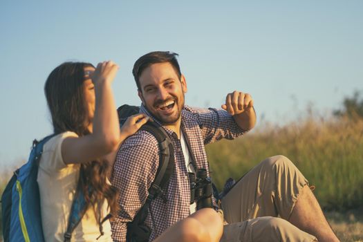 Happy couple is hiking in mountain. They are relaxing.