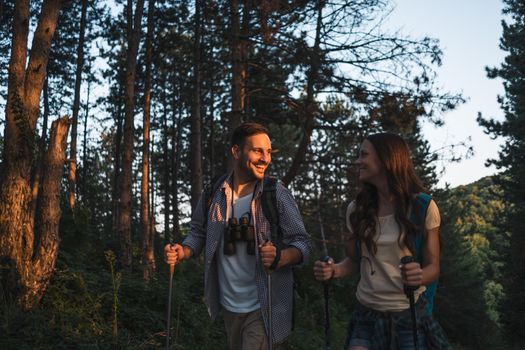 Happy couple is hiking in forest.