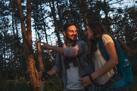 Happy couple is hiking in forest.