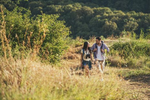 Happy couple is hiking in mountain.