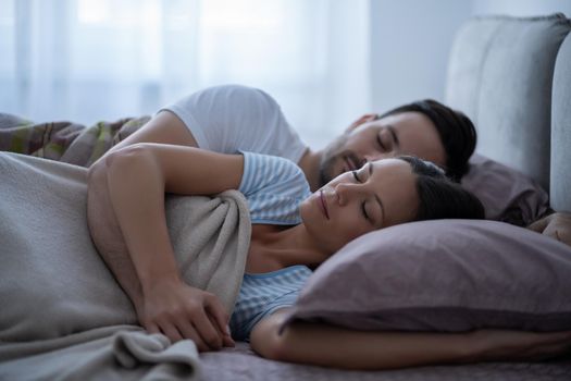 Young couple is lying in bed and sleeping.