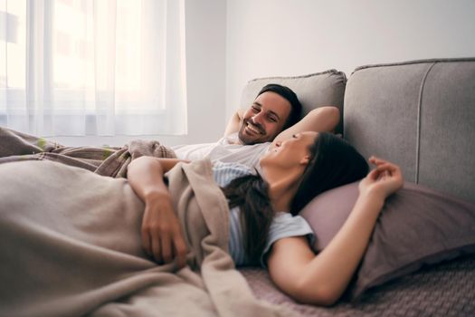 Young happy couple in bed in the morning.