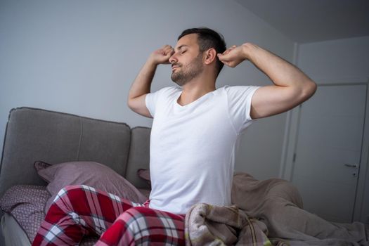 Young couple is sleeping in bed. Man is waking up for work.