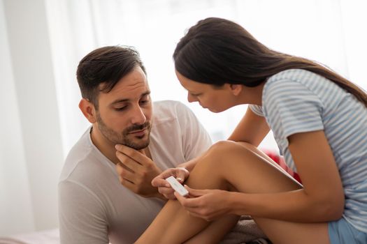 Young couple is anxious anticipating result of pregnancy test.