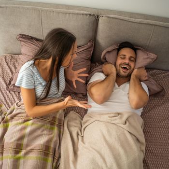 Young couple is arguing in bed.