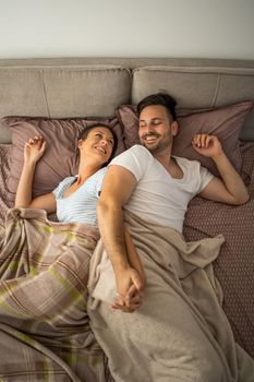 Young couple is resting in bed after work.