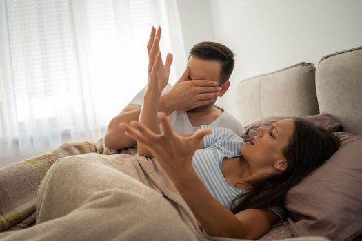 Young couple is arguing in bed in the morning.