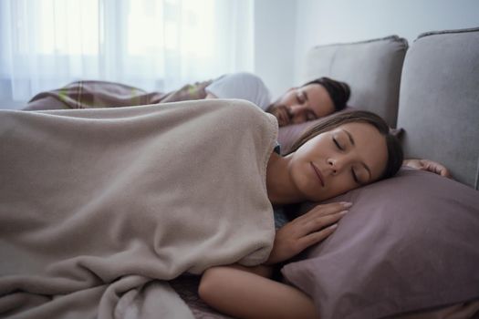 Young couple is lying in bed and sleeping.