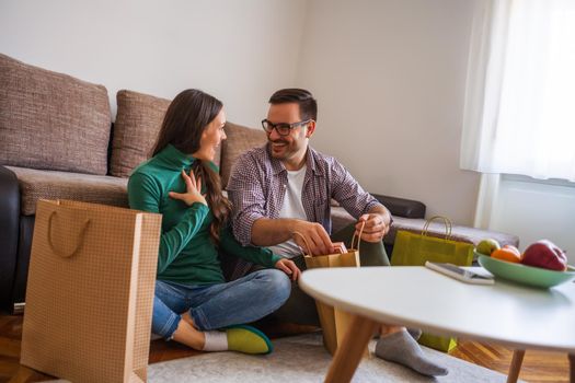 Happy couple is sharing gifts in their home.