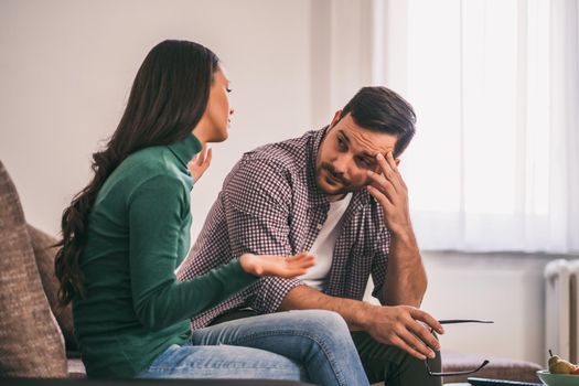 Man and woman are sitting at sofa and arguing. Relationship problems.