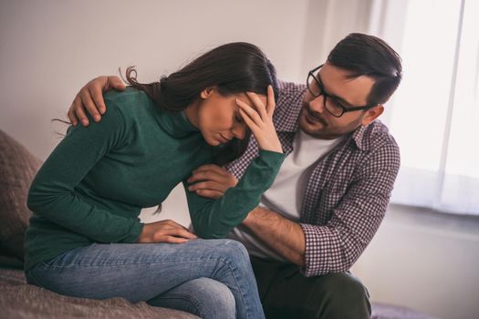 Woman is sad and depressed, her man is consoling her.