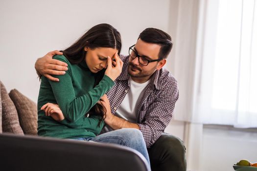 Woman is sad and depressed, her man is consoling her.