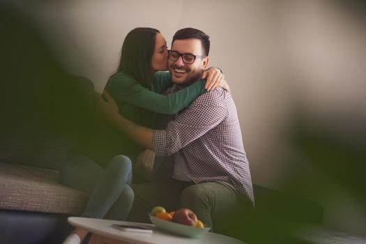 Happy couple in love is embracing at home.