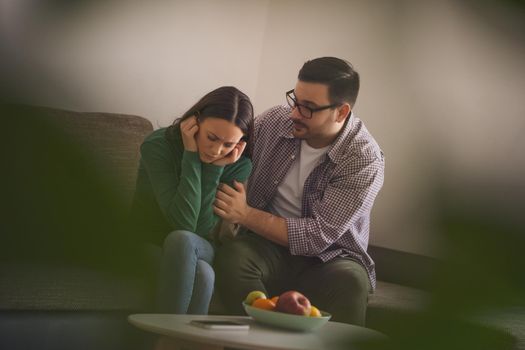 Woman is sad and depressed, her man is consoling her.