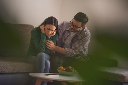 Woman is sad and depressed, her man is consoling her.