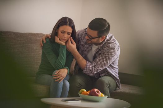 Woman is sad and depressed, her man is consoling her.