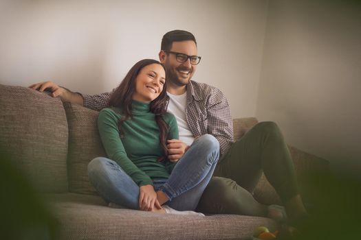 Happy couple in love is relaxing at home.