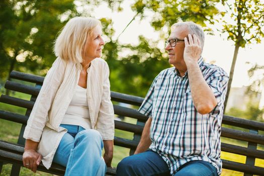 Senior man is talking about headache to friend.