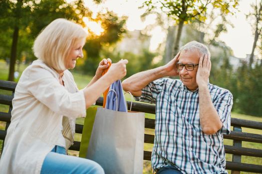 Senior man is angry because his woman is spending money on clothes.