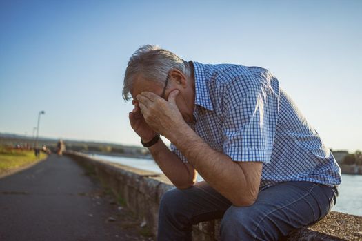 Outdoor portrait of worried and depressed senior man.