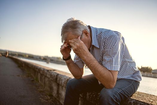 Outdoor portrait of worried and depressed senior man.