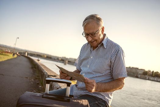 Outdoor portrait of senior man who is on city tour.