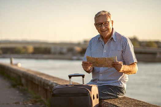 Outdoor portrait of senior man who is on city tour.