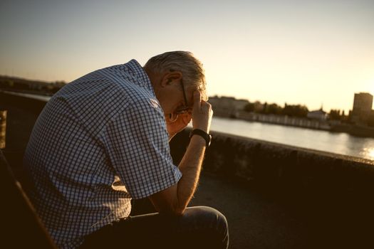 Outdoor portrait of worried and depressed senior man.