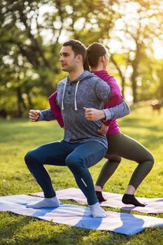 Couple is exercising in park. Exercise for sciatica recovery.