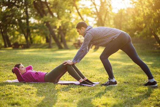 Physical therapist is showing exercises for sciatica recovery to young patient.