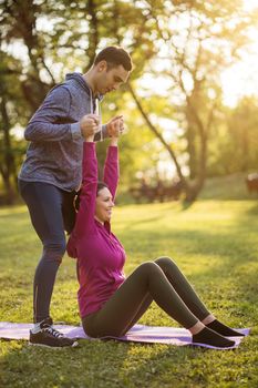 Physical therapist is showing exercises for sciatica recovery to young patient.