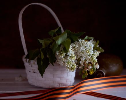 Composition to victory day. Soldier's helmet, ribbons and bouquet of spring flowers. High quality photo