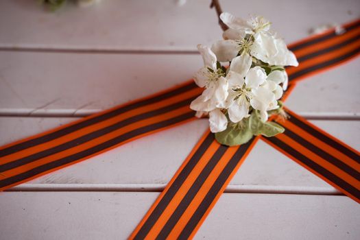 Spring flowers of apple trees with St. George ribbons. Victory Day Photos. High quality photo