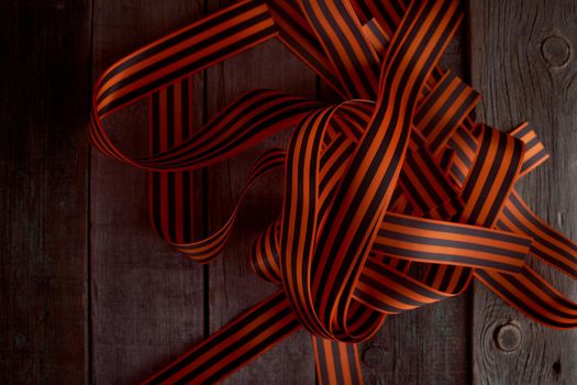 Black orange St. George ribbons on a wooden background. High quality photo