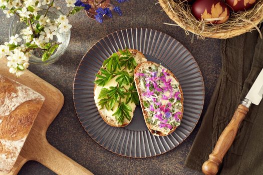 Slices of Sourdough bread with ground elder leaves, lungwort and other wild edible spring plants