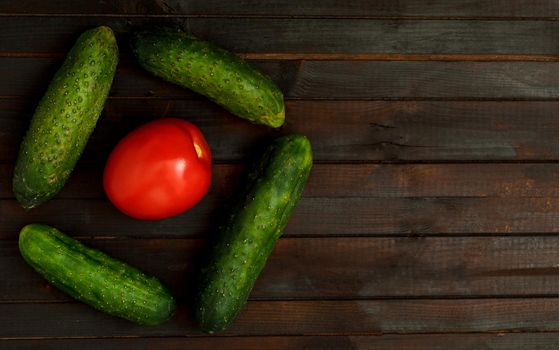 Food background with one tomato and cucumbers vegetables, copyspace.Top view.Vegan diet concept.