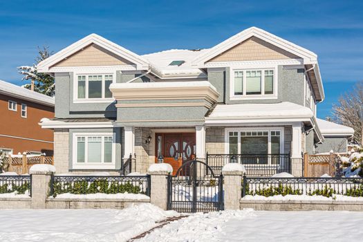 Big luxury residential house in winter season. Luxury family house on winter sunny day in Canada