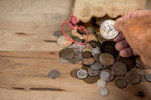 The coin, which was taken out of the bag, is examined with two fingers.