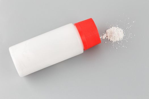 white plastic bottle of baby powder on gray background.