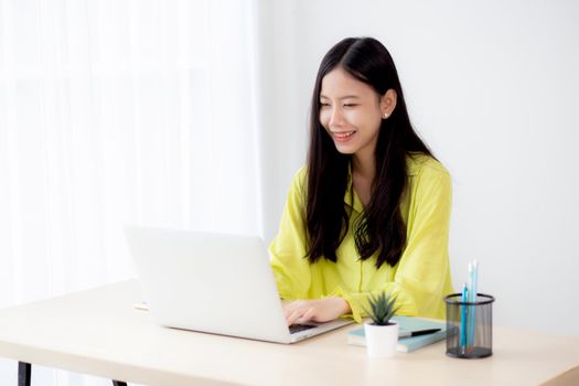 Young asian businesswoman working on laptop computer on desk at home office, freelance looking and typing on notebook on table, lifestyle of woman studying online, business and education concept.